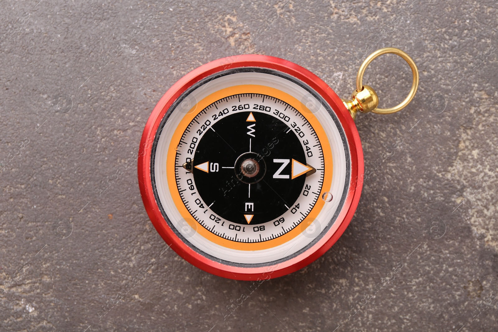 Photo of One compass on grey textured background, top view