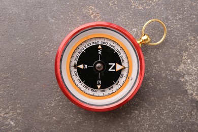 One compass on grey textured background, top view