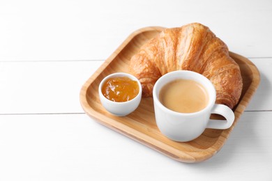 Photo of Breakfast time. Fresh croissant, jam and coffee on white wooden table. Space for text