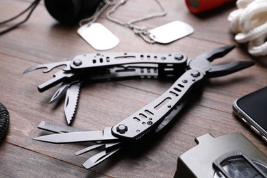 Photo of Modern compact portable multitool and accessories on wooden table