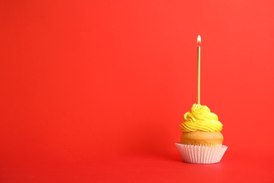 Birthday cupcake with candle on red background, space for text