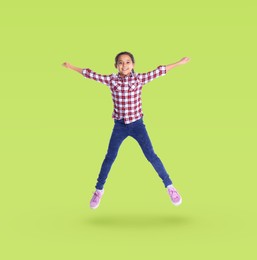 Image of Cute girl jumping on yellowish green background