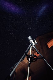 Photo of Modern telescope and beautiful sky in night outdoors, low angle view. Learning astronomy