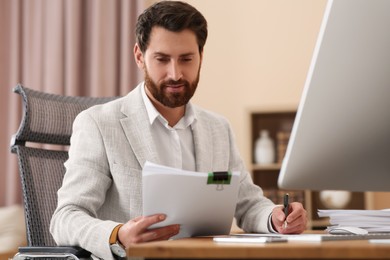 Businessman working with documents at table in office