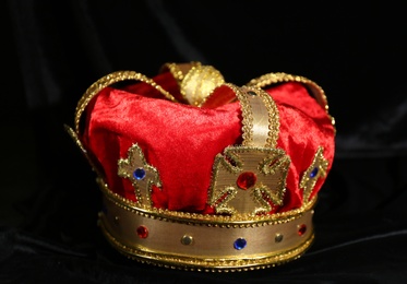 Photo of Beautiful velvet crown on black fabric. Fantasy item