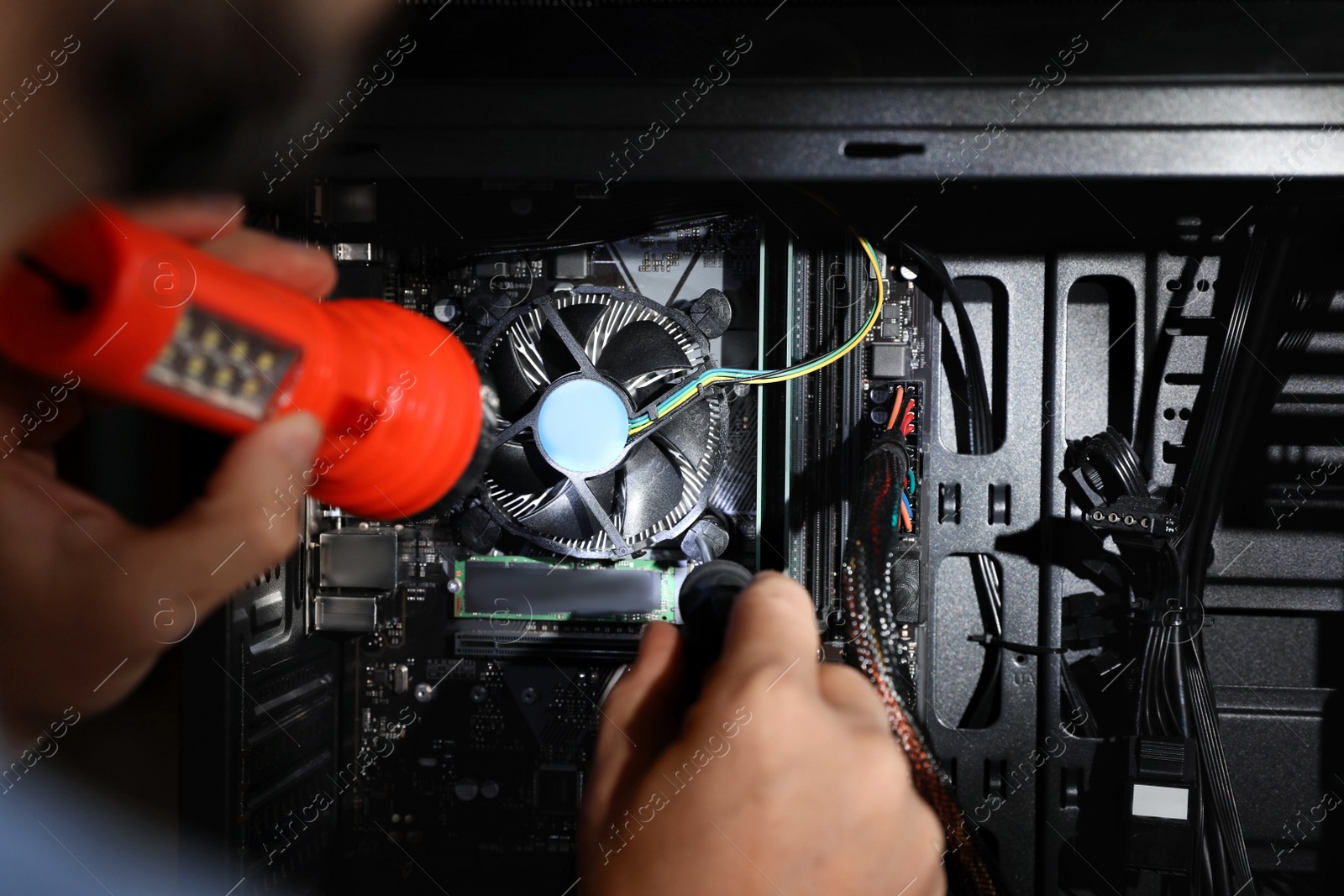 Photo of Man with flashlight fixing system unit indoors, closeup