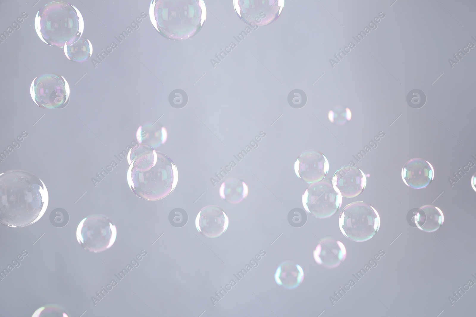 Photo of Beautiful translucent soap bubbles on grey background