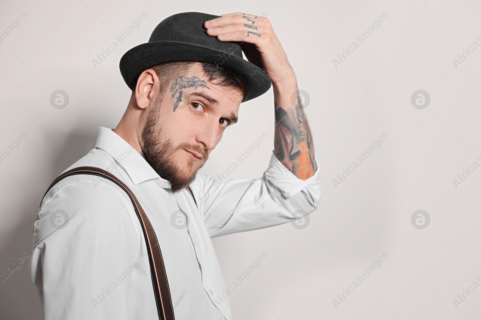 Photo of Portrait of handsome hipster man on light grey background. Space for text