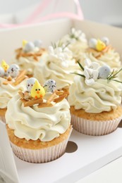 Tasty Easter cupcakes with vanilla cream in box, closeup