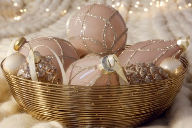 Christmas baubles in bowl on white knitted blanket