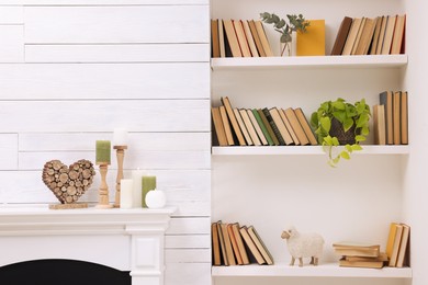 Photo of Collection of books and decor elements on shelves indoors