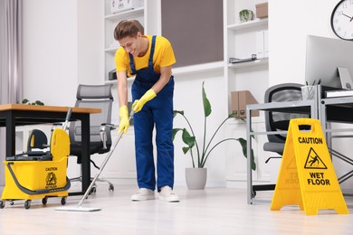 Cleaning service. Man washing floor with mop in office