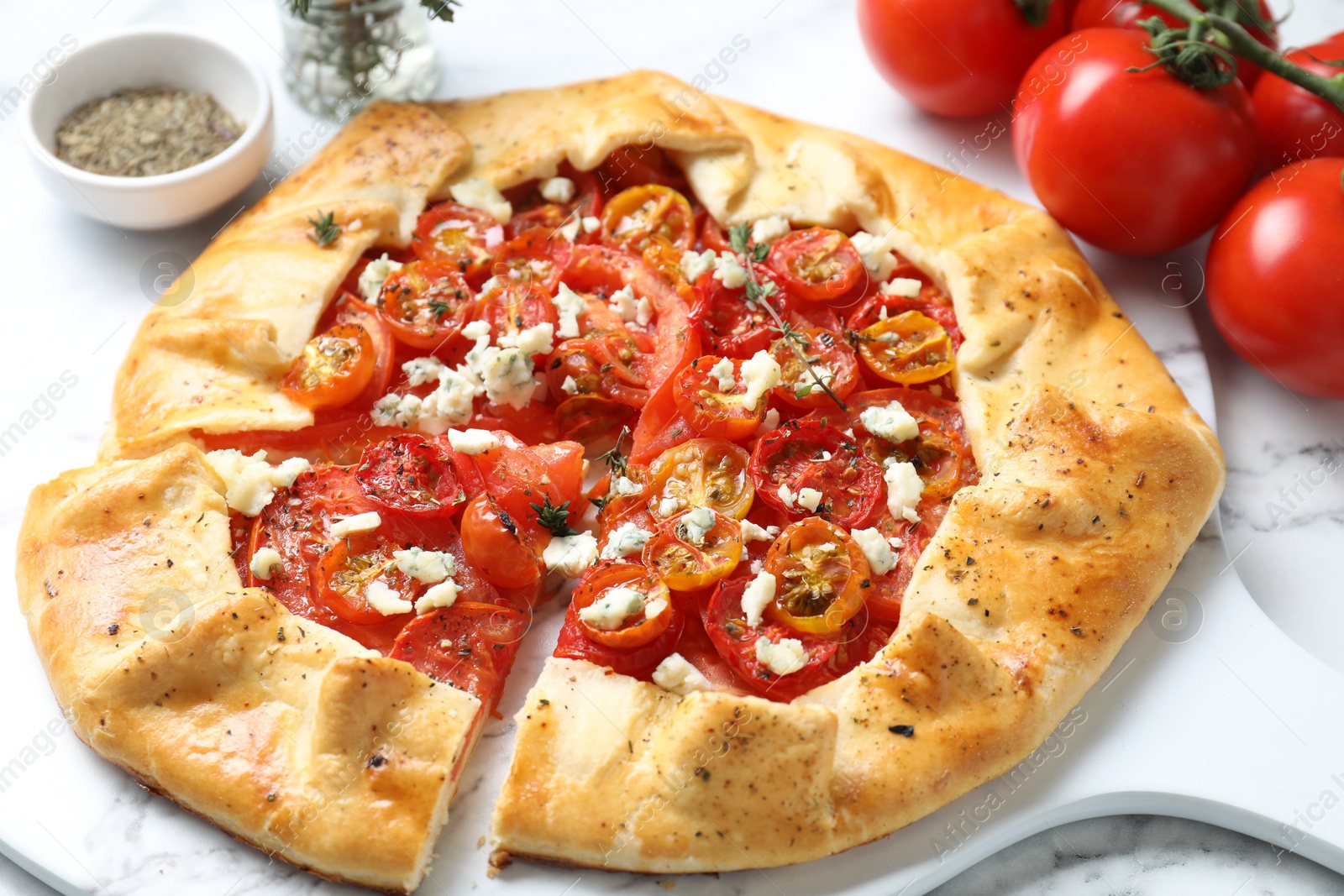 Photo of Tasty galette with tomato, thyme and cheese (Caprese galette) on white table, closeup