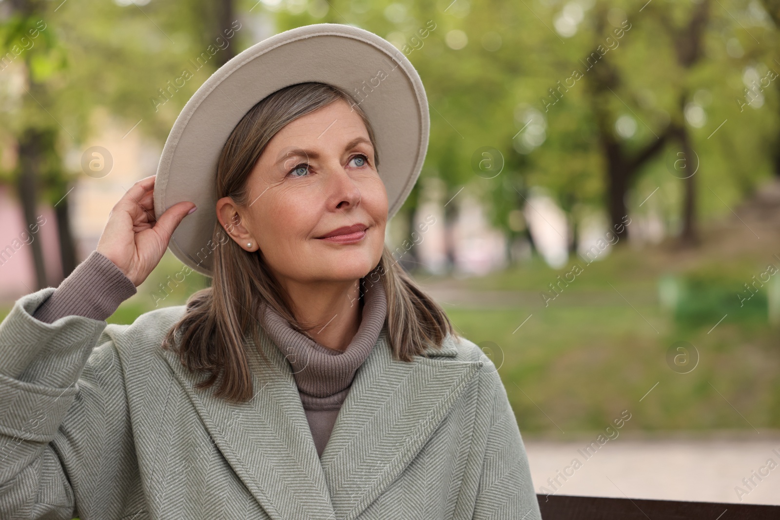 Photo of Beautiful senior woman outdoors, space for text