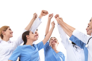 Photo of Team of medical doctors raising hands together on white background. Unity concept