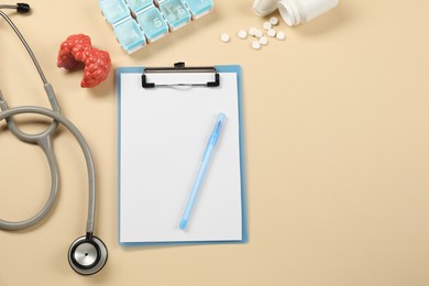 Photo of Endocrinology. Flat lay composition with clipboard and model of thyroid gland on beige background, space for text