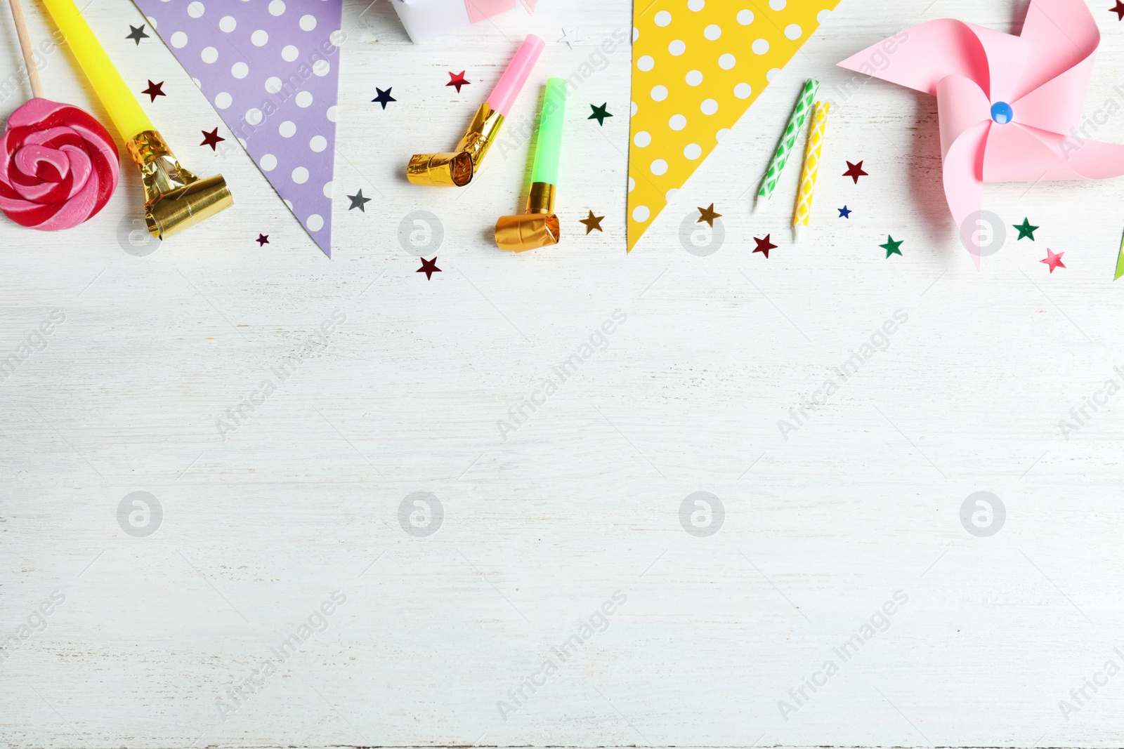 Photo of Colorful birthday accessories on white wooden background, flat lay. Space for text