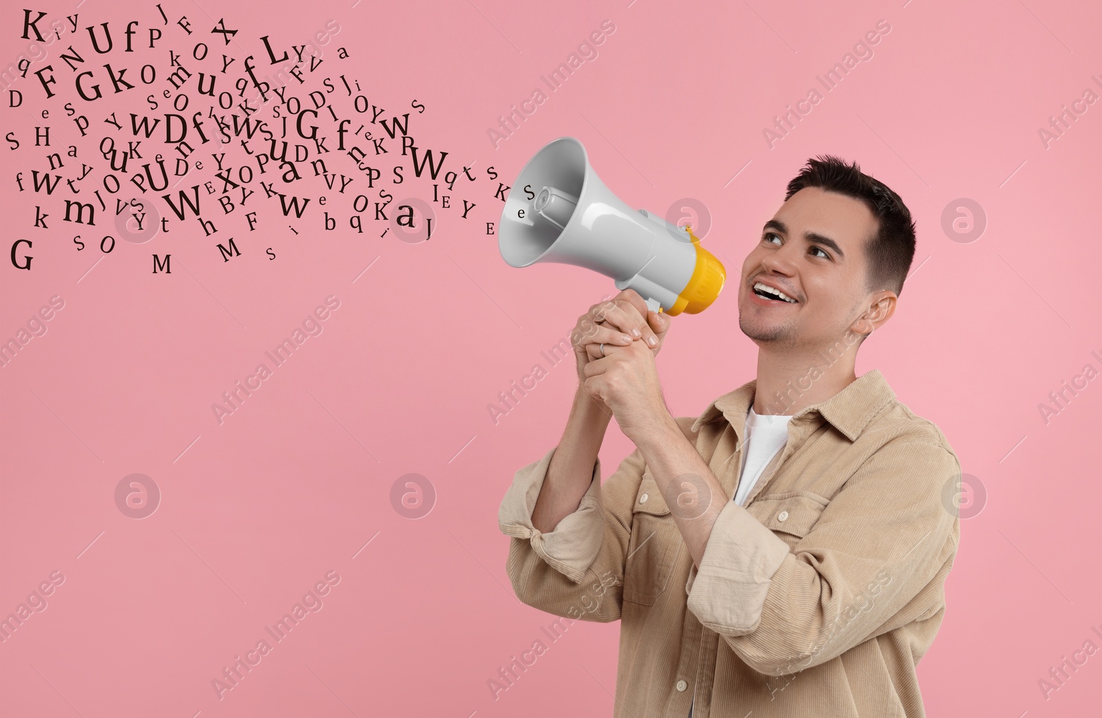 Image of Man using megaphone on pink background. Letters flying out of device