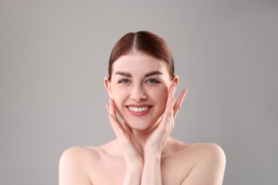 Photo of Portrait of smiling woman on grey background