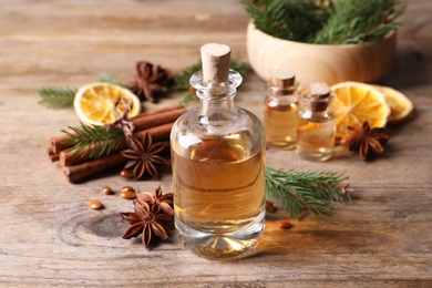 Photo of Anise essential oil and spices on wooden table