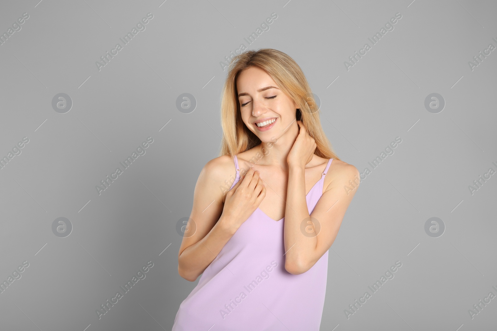 Photo of Portrait of beautiful young woman with blonde hair on grey background