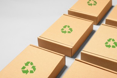 Image of Cardboard boxes with recycle sign stamps on light grey background, space for text