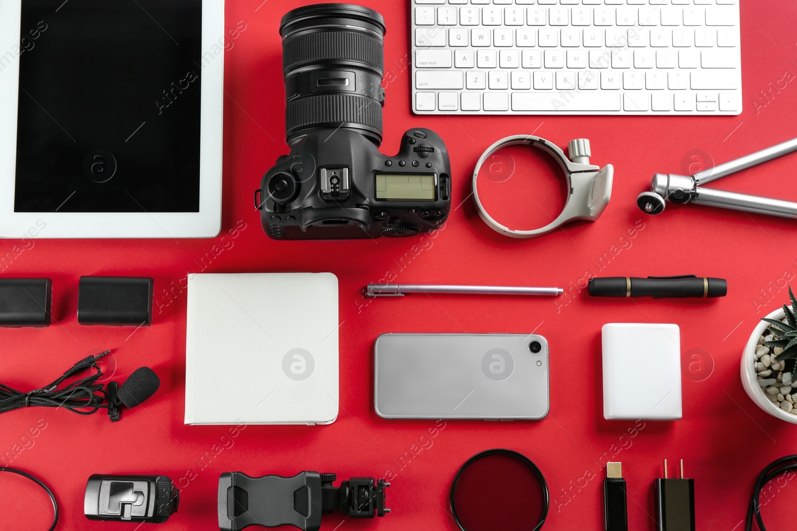 Photo of Flat lay composition with camera and video production equipment on red background