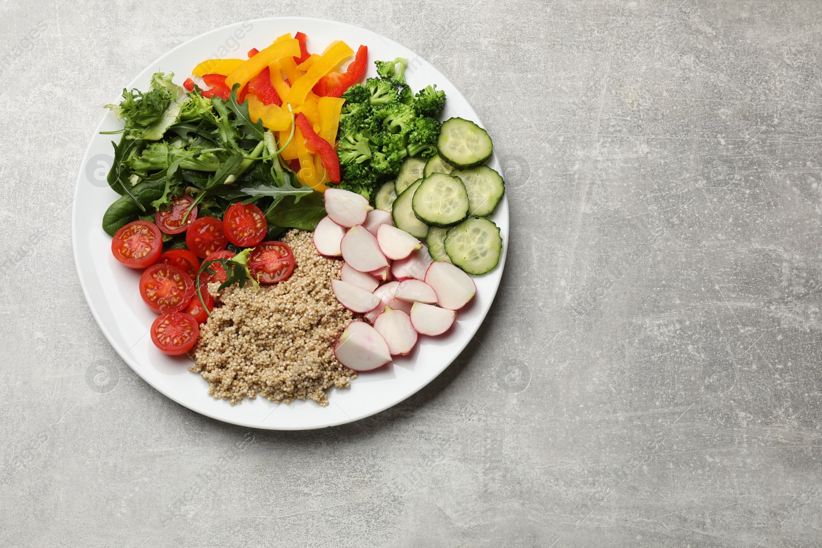 Photo of Vegetarian diet. Plate with tasty vegetables and quinoa on light grey table, top view. Space for text