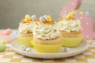 Tasty Easter cupcakes with vanilla cream on table, closeup