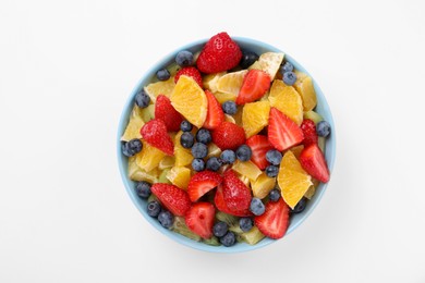 Yummy fruit salad in bowl on white background, top view