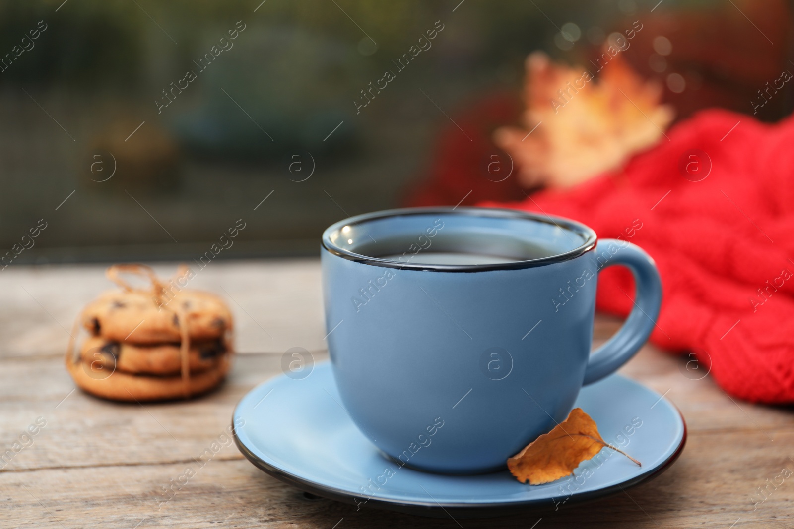 Photo of Cup of hot drink and cookies on window sill indoors. Cozy autumn atmosphere