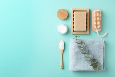 Photo of Jar of cream, body care products and eucalyptus branch on turquoise background, flat lay. Space for text