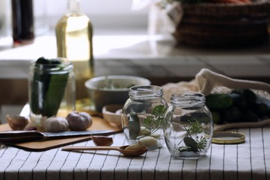 Empty glass jars and ingredients prepared for canning on table indoors