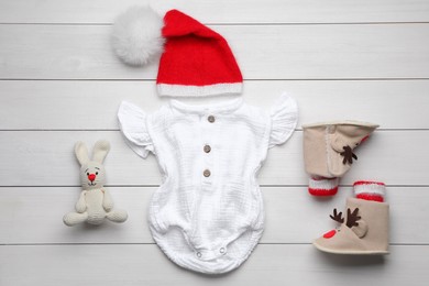 Flat lay composition with child's clothes on white wooden table