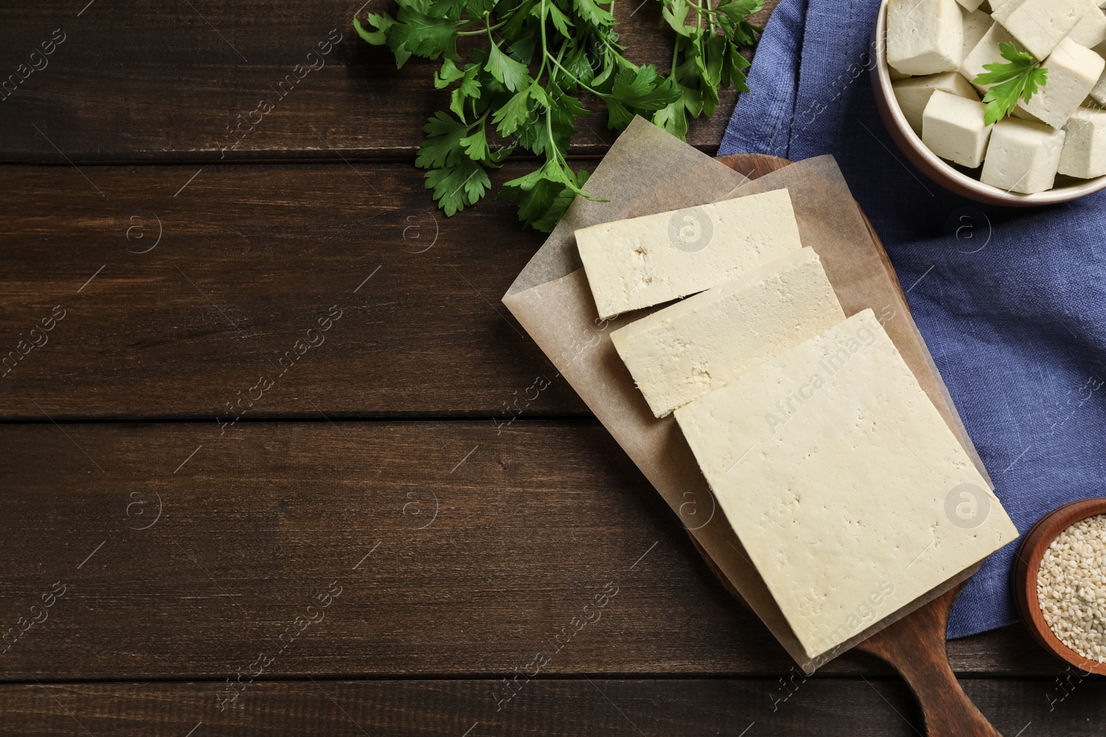 Photo of Delicious tofu served on wooden table, flat lay. Space for text