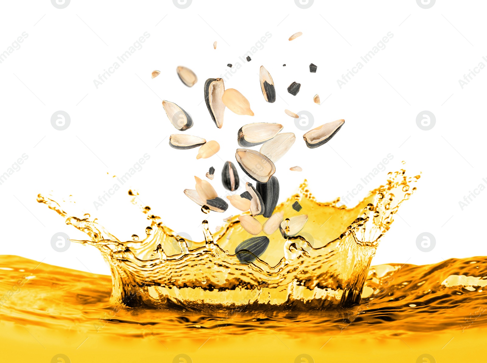 Image of Sunflower seeds falling into cooking oil on white background