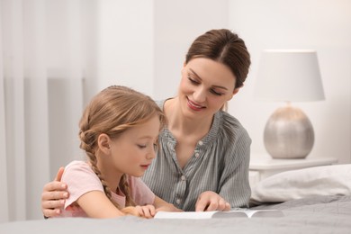 Girl and her godparent reading Bible together at home