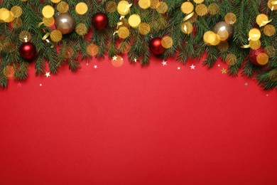 Photo of Flat lay composition with fir tree branches and Christmas decor on red background, space for text. Bokeh effect