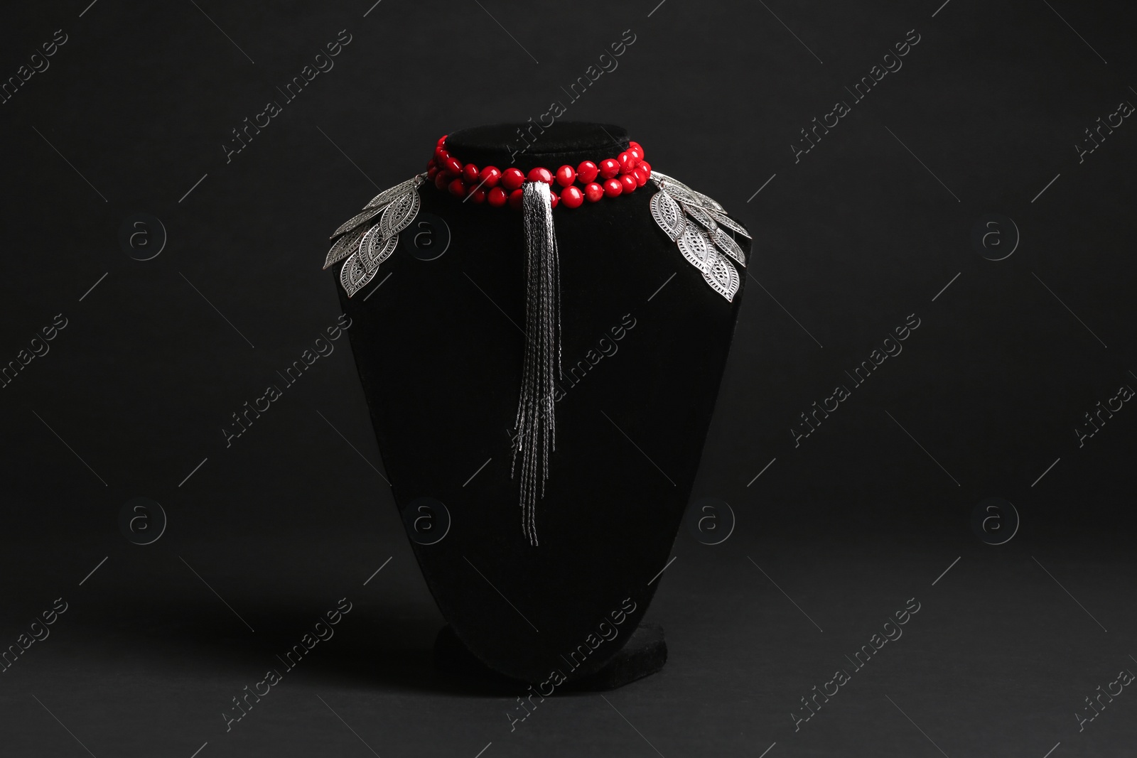 Photo of Set of luxury jewelry on stand against black background