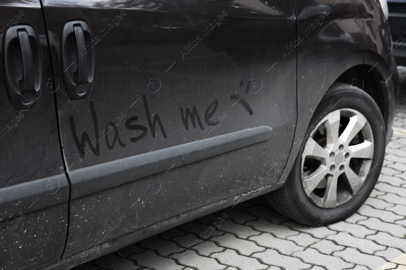 Photo of Inscription WASH ME and sad smiley on dirty car outdoors, closeup