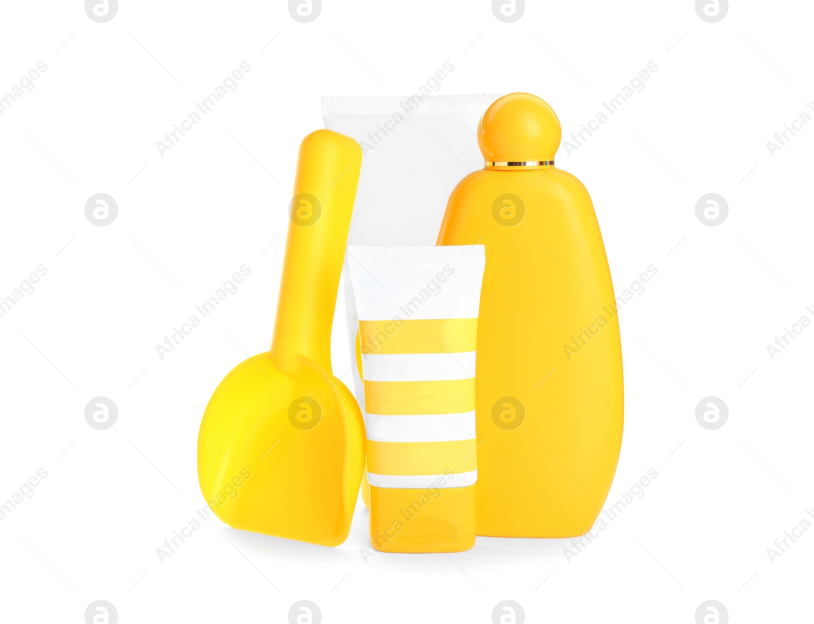 Photo of Different suntan products and plastic beach toy on white background