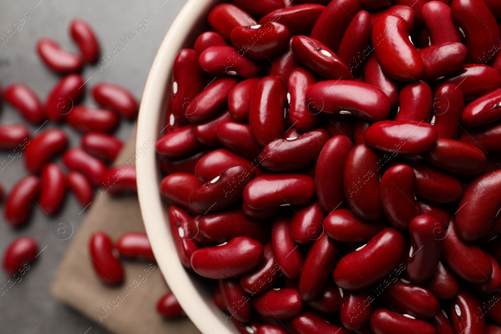 Photo of Bowl of raw red kidney beans on table, top view