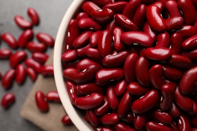 Photo of Bowl of raw red kidney beans on table, top view