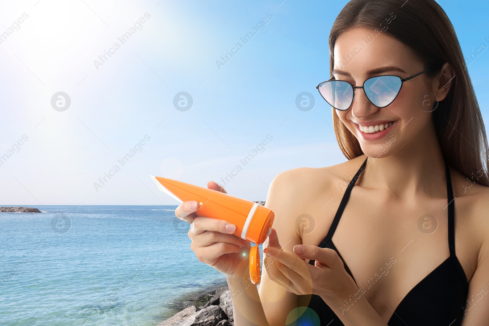 Image of Young woman applying sun protection cream at beach, space for text