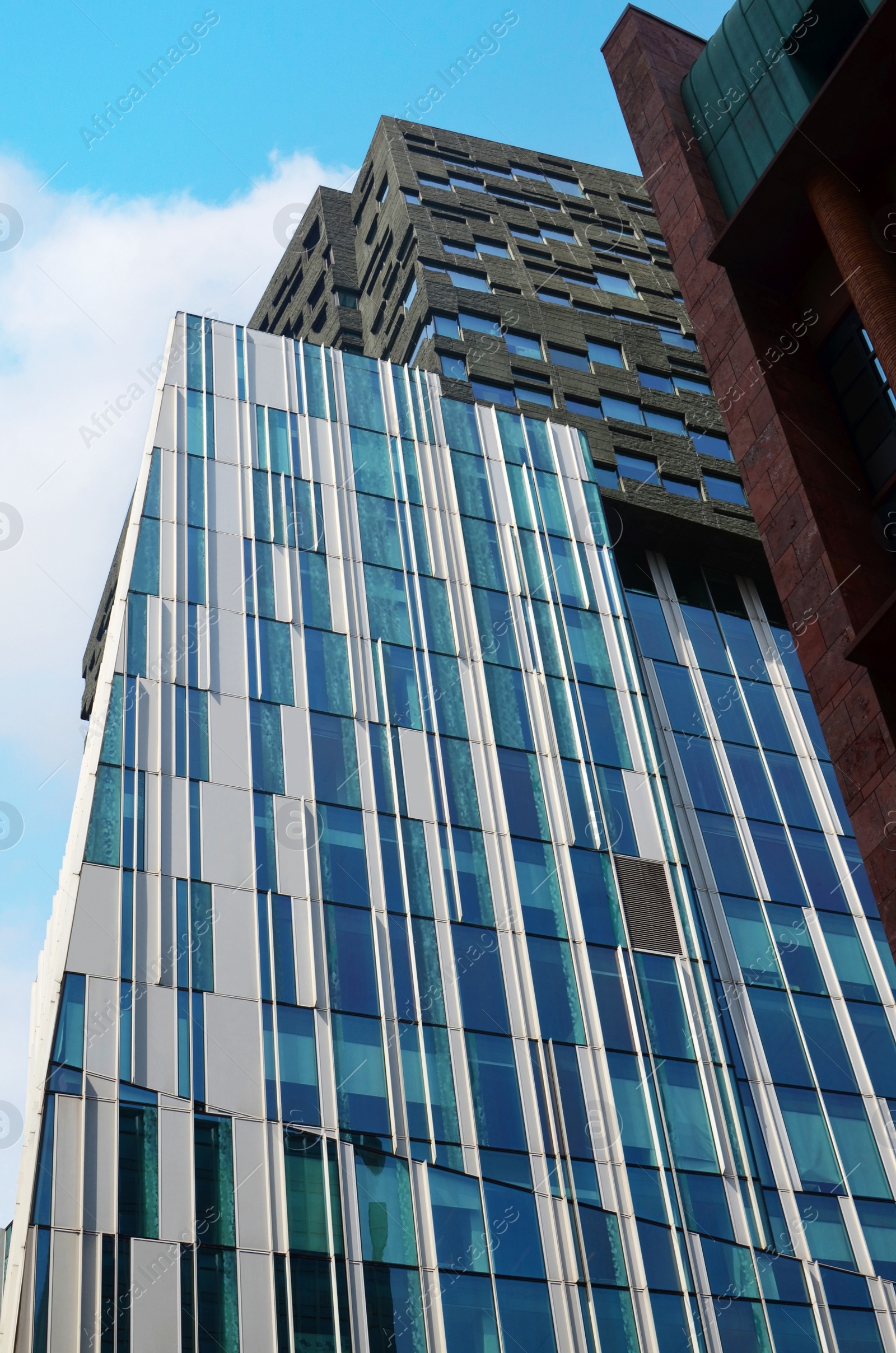 Photo of Exterior of beautiful modern skyscraper against blue sky, low angle view