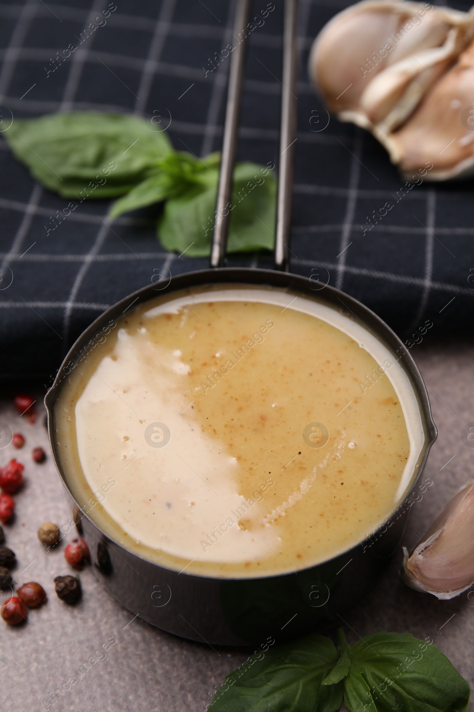 Photo of Delicious turkey gravy, basil, peppercorns and garlic on brown textured table, closeup