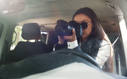 Photo of Private detective with camera spying from car