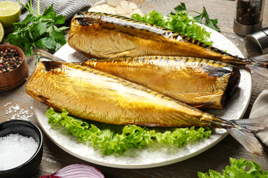 Photo of Tasty smoked fish served on wooden table