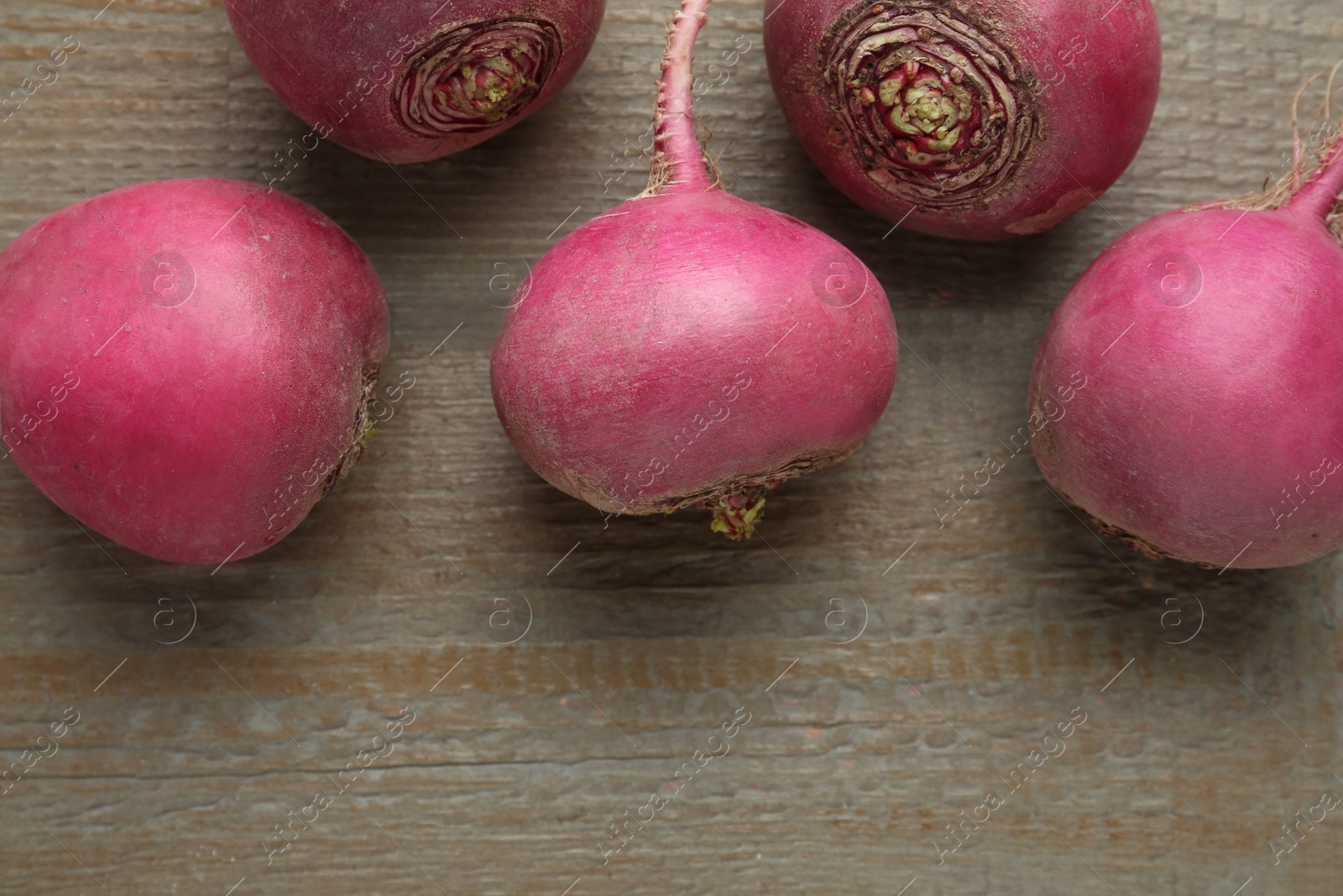 Photo of Red turnips on wooden table, flat lay. Space for text