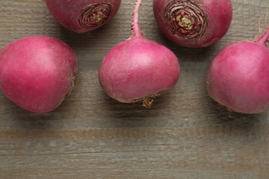 Red turnips on wooden table, flat lay. Space for text